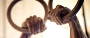 A GymnasticBodies athlete demonstrates how a false grip looks on the rings.