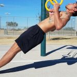 GymnasticBodies athlete demonstrates ring rows, which develop shoulder strength and flexibility.