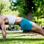 GymnasticBodies female athlete demonstrates shoulder mobility and core strength with a reverse plank.