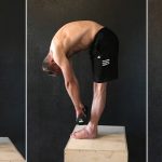 GymnasticBodies athlete demonstrates a full body stretch with Jefferson Curls.