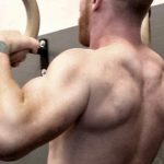 GymnasticBodies athlete shows off biceps that develop with advanced ring work.