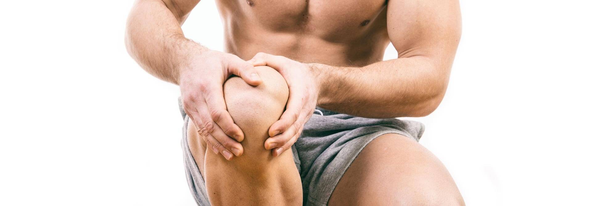 Athlete holds knee in pain because he didn't prehab them with GymnasticBodies progressions.